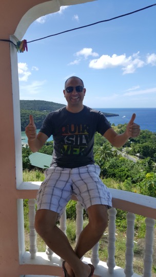 Steve Clarke wearing a t-shirt, giving thumbs up on a balcony overlooking the Caribbean